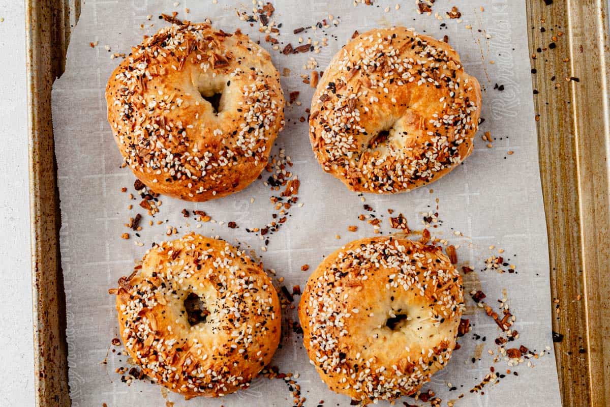 freshly baked everything cottage cheese bagels on a parchment line baking sheet