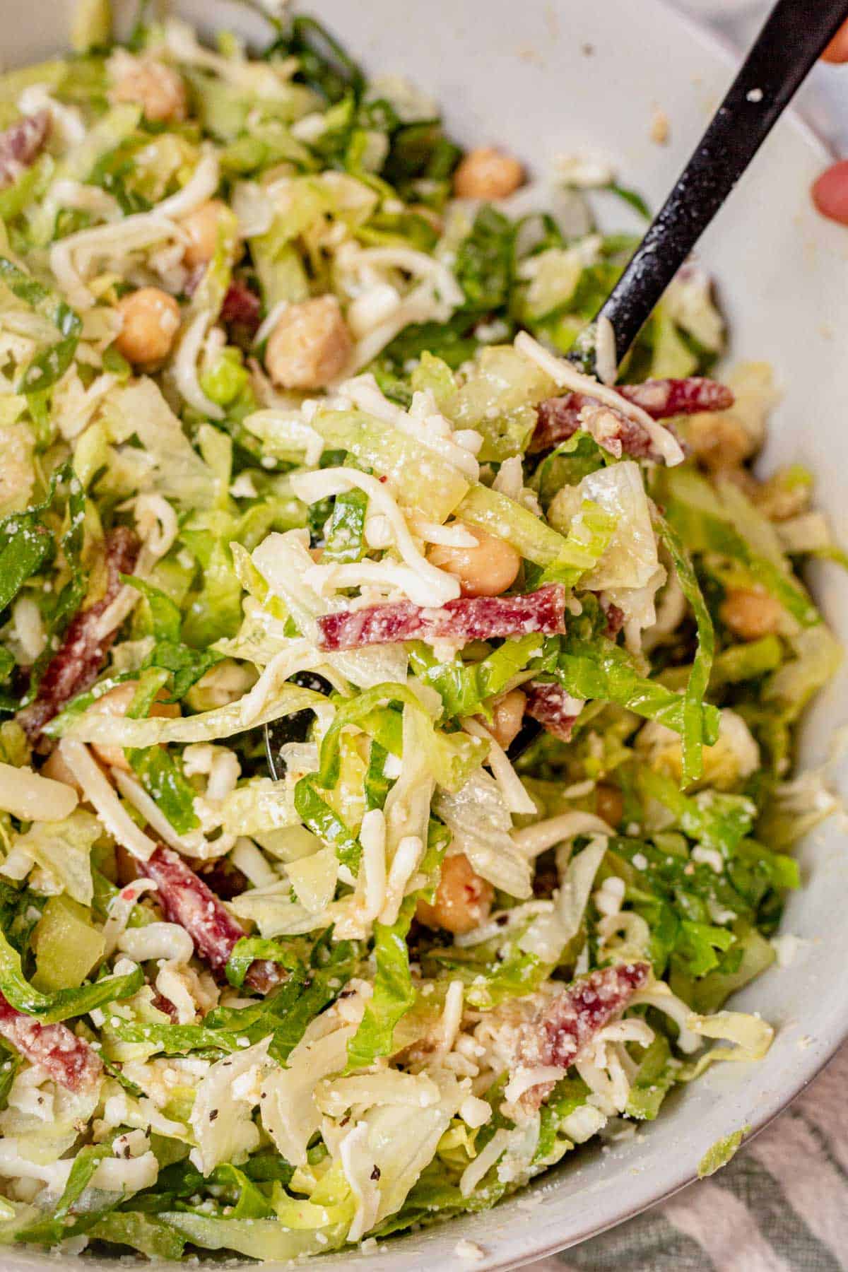 scooping la scala chopped salad out of a bowl