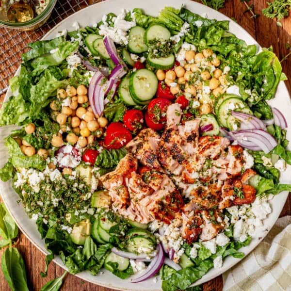 Overhead close-up of salmon salad with flaked salmon, chickpeas, cucumber, and fresh herbs.